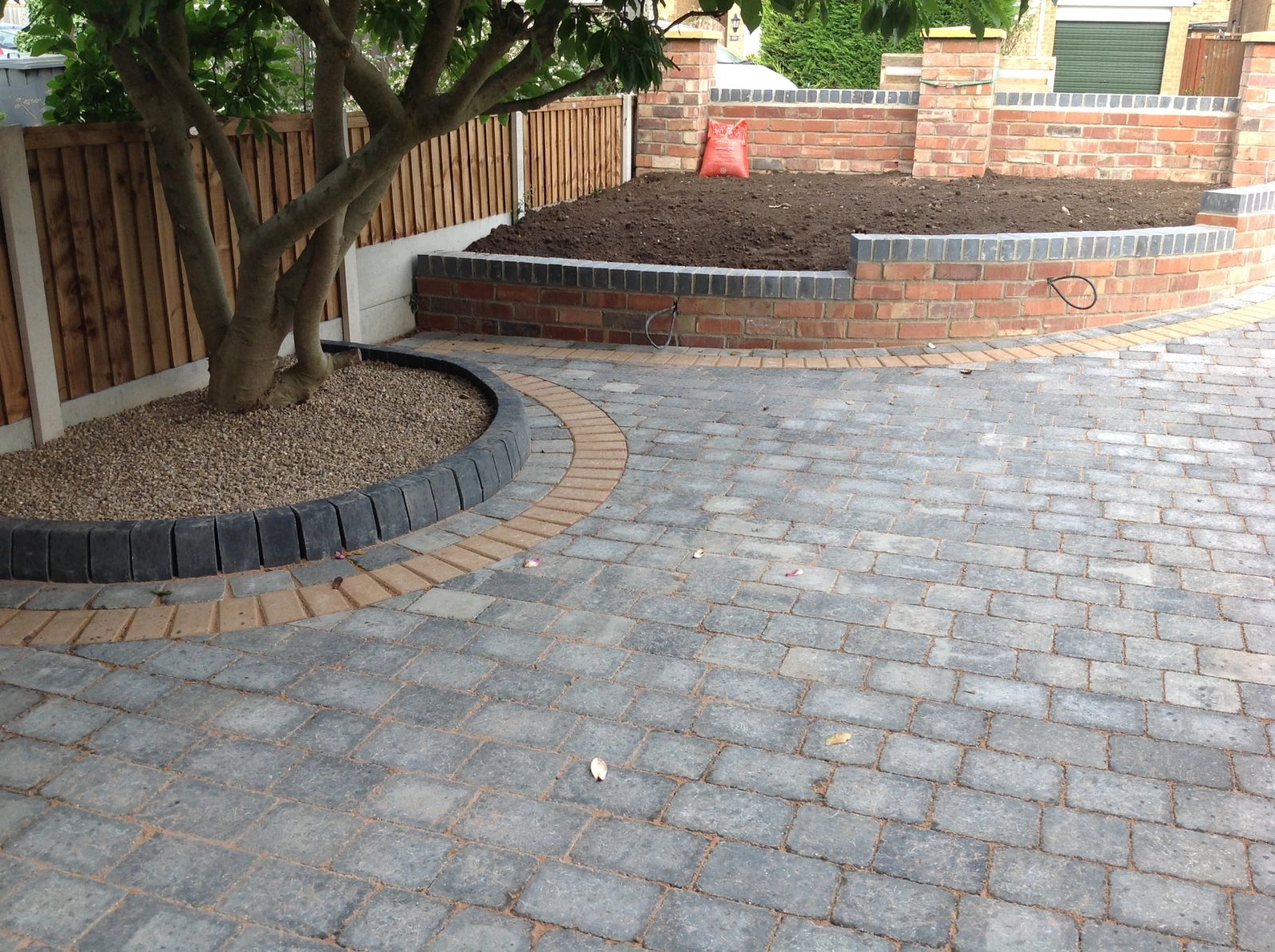 Grey cobble-effect block paving with raised brick planters